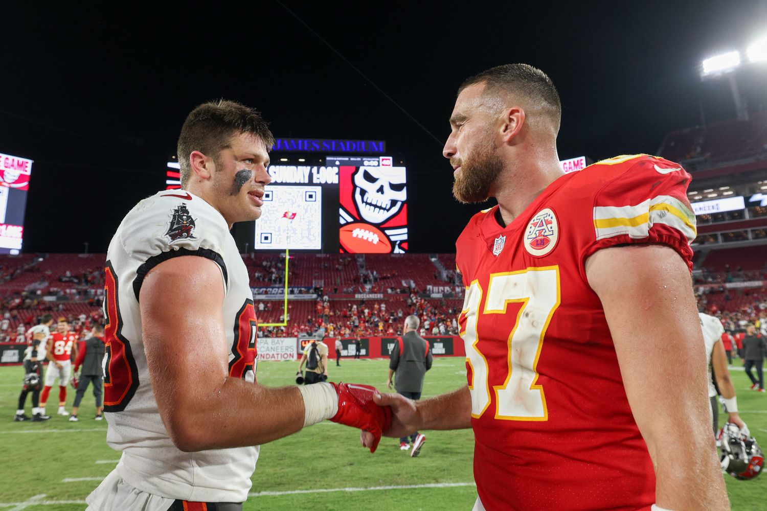 Kansas City Chiefs tight end Travis Kelce (87) greets Tampa Bay Buccaneers tight end Cade Otton (88) after a game at Raymond James Stadium.
